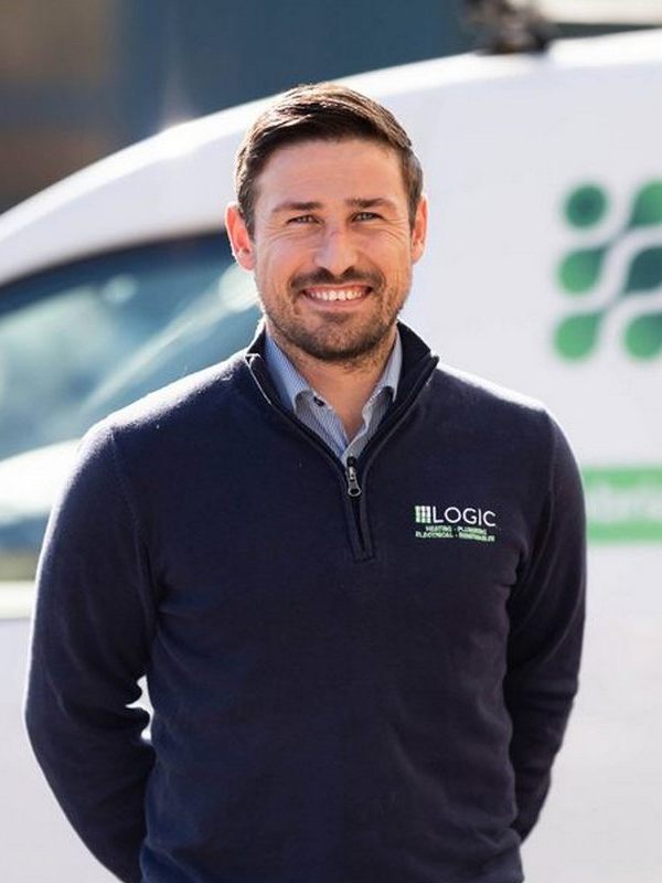 Why Us Home Page v3 Man standing in front of a Logic Plumbing Electrical and Heating van